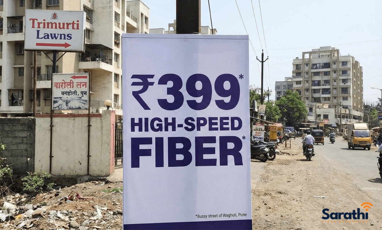 A roadside banner in Wagholi, Pune, advertising "₹399 HIGH-SPEED FIBER" with a small asterisk, located near Trimurti Lawns.