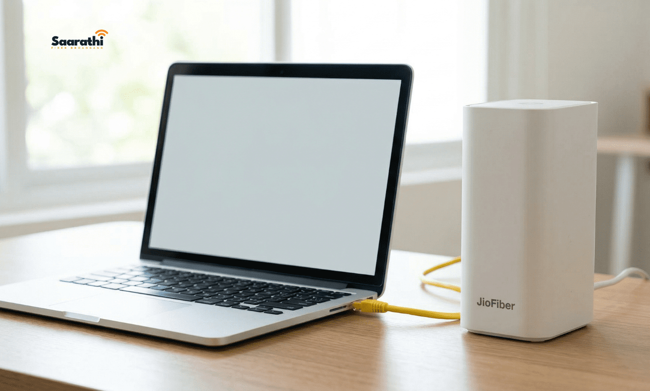 Laptop connected to a white JioFiber router using a yellow ethernet cable for local admin configuration.